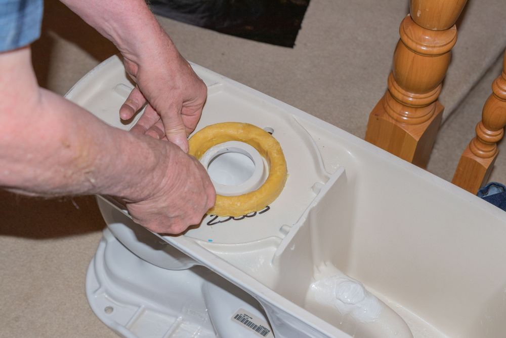 person placing wax ring on toilet person placing wax ring on toilet