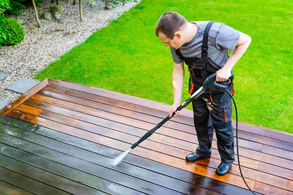 Man Pressure Washing a Deck