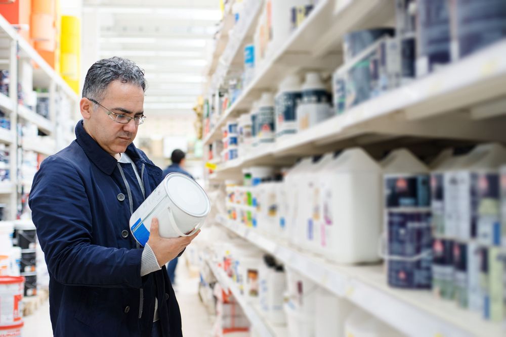 Homeowner Shopping for Paint in the Paint Aisle Of a Hardware Store.