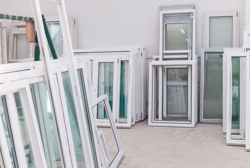 10 Essential Factors to Consider When Shopping for Replacement Windows dozens of replacement windows stacked and leaning against wall